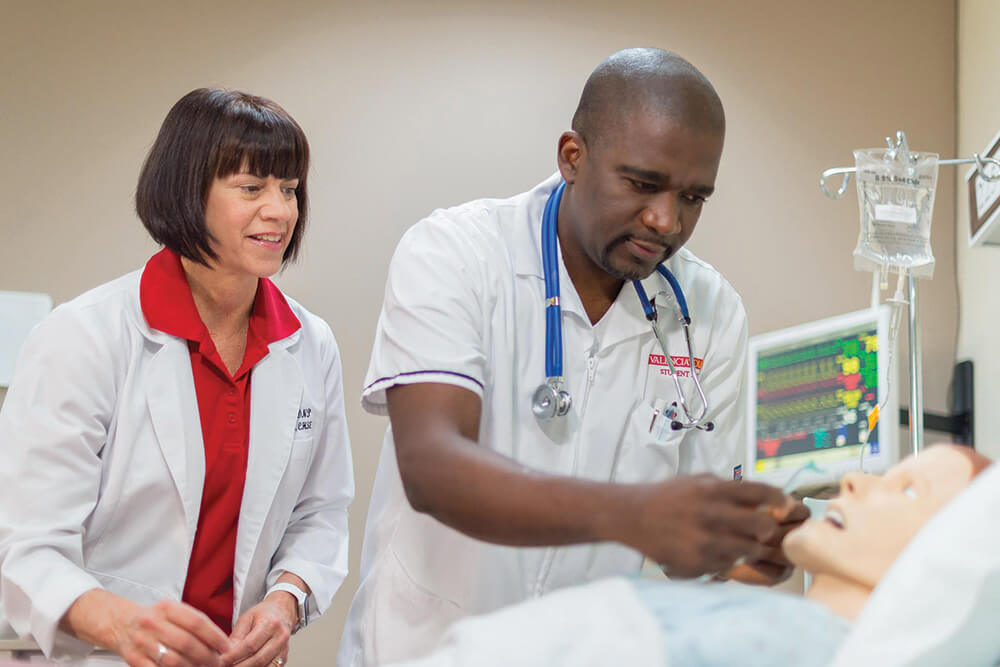 Nursing lab, male nurse training with female instructor