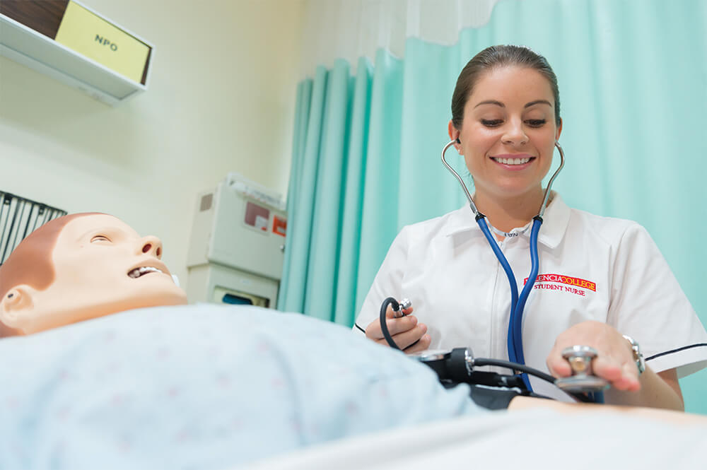 Nursing lab, female nurse with nursing mannequin